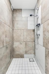 a bathroom with a shower with a tiled wall at Juhkentali 46, korter 5 in Tallinn