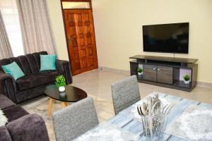 a living room with a couch and a tv at Stylish 2 bedroom in Kitale Fully Furnished in Kitale