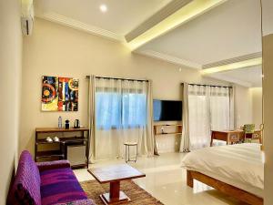 um quarto com uma cama e um sofá em Le Kentia em Lomé