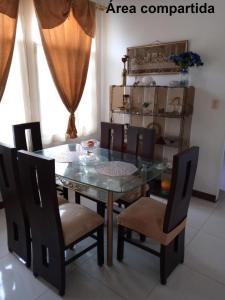 uma sala de jantar com uma mesa de vidro e cadeiras em Acuarela del Rio H#1 Cerca Terminal Terrestre Habitación privada con baño em Guayaquil