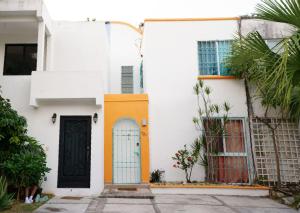 Casa blanca con puertas coloridas y palmeras en Casa de Colores, en Playa del Carmen