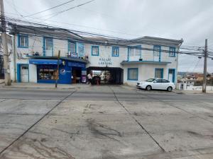 a white car parked in front of a blue building at Casa Grande En Recreo in Viña del Mar