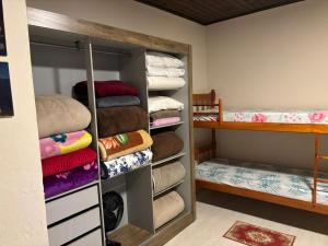 Habitación con armario con toallas y litera. en Casa completa, simples e aconchegante em Urubici., en Urubici