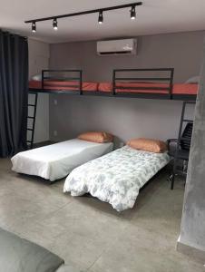 two beds in a room with two bunk beds at Studio Flex com garagem e piscina no centro de Sp in Sao Paulo +37 photos