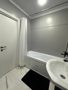 CăuşeniSânzâiana House 3的带浴缸和水槽的白色浴室