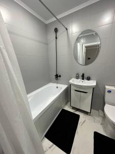 a white bathroom with a tub and a sink at Sânzâiana House in Căuşeni
