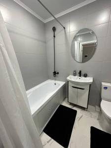 CăuşeniSânzâiana House 3的带浴缸和水槽的白色浴室 更多15张照片