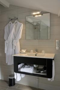 a bathroom with a sink and a mirror at Hôtel Restaurant Des Remparts in Chaumont