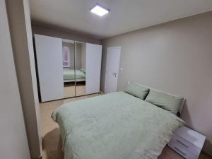 1 dormitorio con 1 cama grande y espejo en SweetPlace Forever in Charleroi (Appart2), en Charleroi