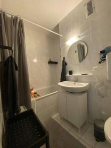 ein Badezimmer mit einem Waschbecken, einem Spiegel und einer Badewanne in der Unterkunft Stylish flat close to Basel with a stunning view in Weil am Rhein