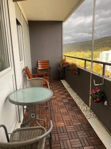 einen Balkon mit einem Tisch und Stühlen sowie einem Fenster in der Unterkunft Stylish flat close to Basel with a stunning view in Weil am Rhein