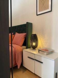 ein Schlafzimmer mit einem Bett und einem Tisch mit einer Lampe in der Unterkunft Stylish flat close to Basel with a stunning view in Weil am Rhein