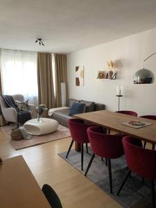 ein Wohnzimmer mit einem Sofa, einem Tisch und Stühlen in der Unterkunft Stylish flat close to Basel with a stunning view in Weil am Rhein