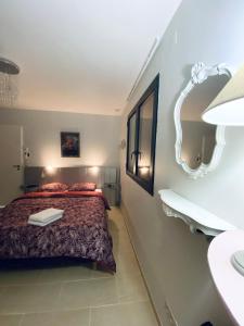 een kleine slaapkamer met een bed en een spiegel bij L’écrin des bois in Mansac