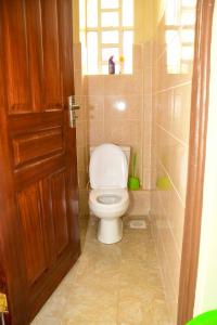 La salle de bains est pourvue de toilettes blanches et d'une porte. dans l'établissement Cozy 2 bedroom in Kitale-Fully Furnished at 360 Luxury, à Kitale 12 autres photos