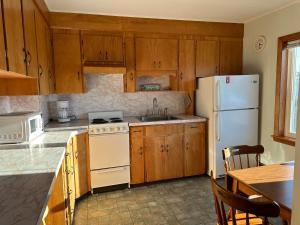 旧奥查德比奇Moontide Motel, Apartments, and Cabins的配有木质橱柜和白色冰箱的厨房