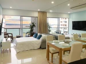 a bedroom with a bed and a living room with a table at Bocagrande Infinitum Vista mar Gym Coworking in Cartagena de Indias