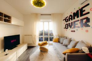 - un salon avec un canapé et une télévision dans l'établissement [Arcade House] Verona Fiera Netflix + Videogame, à Vérone