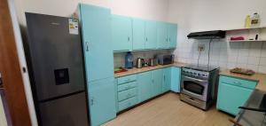 a kitchen with blue cabinets and a refrigerator at R.KAWIMBE FURNISHED APARTMENTS in Lusaka