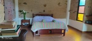 a bedroom with a bed and a table with a vase at Encanto - Habitación con baño privado in Villa de Leyva