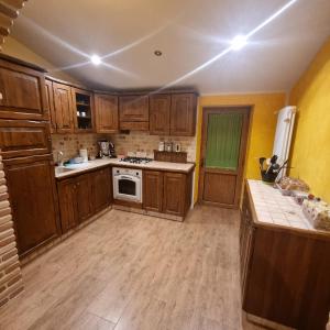 a kitchen with wooden cabinets and a stove top oven at Ginsan's House in Carceri +7 photos