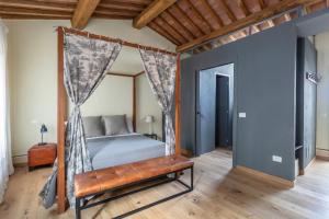 1 dormitorio con cama con dosel y banco en Tuscany View Montalcino, en Montalcino