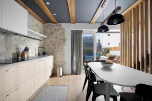 a kitchen with a table and a dining room at Villa Sulic - Heated Pool and Mountain View in Zagvozd