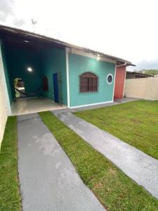 a house with a grass yard next to a building at Casa Excelente Praia Grande in Fundão