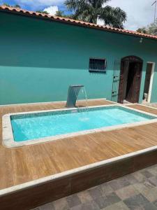 a swimming pool in front of a blue house at Casa Excelente Praia Grande in Fundão