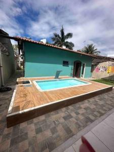 a swimming pool in front of a house at Casa Excelente Praia Grande in Fundão