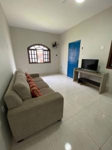Casa Excelente Praia Grande في فانداو: غرفة معيشة بها أريكة وتلفزيون