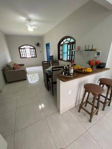 a kitchen and living room with a table and chairs at Casa Excelente Praia Grande in Fundão