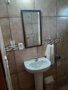 een badkamer met een wastafel en een spiegel bij Estadía Nuestro Sueño in Colonia del Sacramento