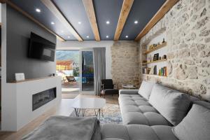 sala de estar con sofá y pared de piedra en Villa Sulic - Heated Pool and Mountain View, en Zagvozd