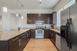 a large kitchen with wooden cabinets and appliances at Spacious 2br Corporate Suite, Parking, Pool Cs in Dallas