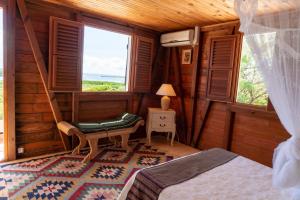 a bedroom with a bed and a chair and a window at Villa Mawali in Sainte-Anne