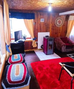 sala de estar con 2 reposapiés y sofá en Cabañas don Vicente, en Dalcahue