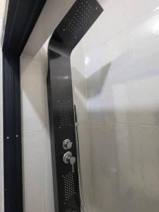 una doccia con soffione nero su una parete di Home Away From Home 