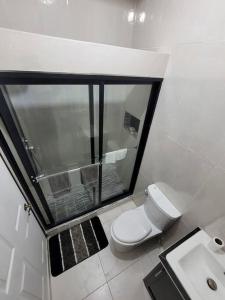 a white bathroom with a toilet and a sink at Home Away From Home 