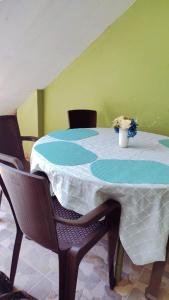 una mesa con sillas y un jarrón de flores. en Residencia Isidora - Casa de Playa, en Punta Hermosa