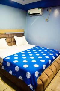 a bed with a blue and white polka dot blanket at Appartement/Studio meublé a Bangui in Bangui