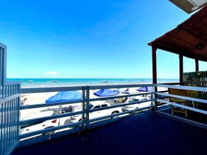 einen Balkon mit Blick auf den Strand und die Boote in der Unterkunft Apê 4: Pé na Areia Maragogi - O Caribe Brasileiro in Maragogi
