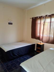 een slaapkamer met 2 bedden en een raam bij Recanto Betânia 