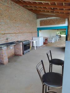 een kamer met stoelen en tafels en een bakstenen muur bij Recanto Betânia 