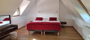 Un dormitorio con una cama con almohadas rojas. en Longère rénovée sur les hauteurs de Perros-Guirec en Perros-Guirec
