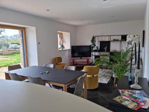 uma sala de estar com mesa e cadeiras em Longère rénovée sur les hauteurs de Perros-Guirec em Perros-Guirec