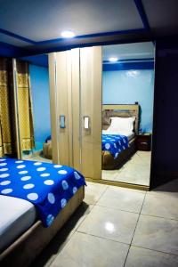 バンギにあるAppartement/Studio meublé a Banguiの鏡付きのベッドルーム1室、ベッド1台が備わるベッドルーム1室を提供しています。