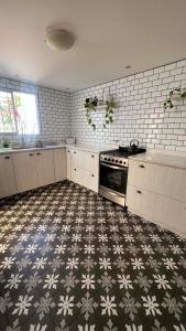 uma cozinha com piso em azulejo e um fogão em CASA EN LA FELIZ - pet friendly em Mar del Plata