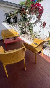 two chairs and a table on a patio with flowers at CASA EN LA FELIZ - pet friendly in Mar del Plata