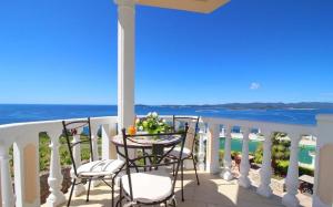 balcón con mesa, sillas y vistas al océano en Pansion Villa Antonio en Orebić